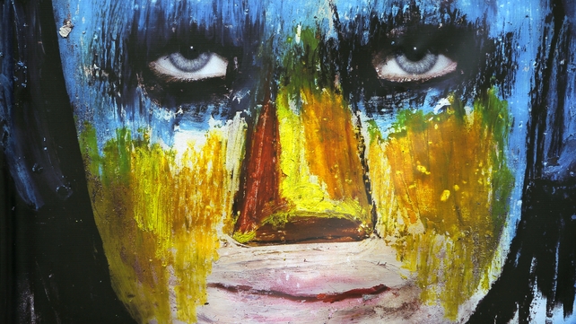 Artwork shows the face of a young protester painted blue and yellow at a makeshift gallery in Kiev