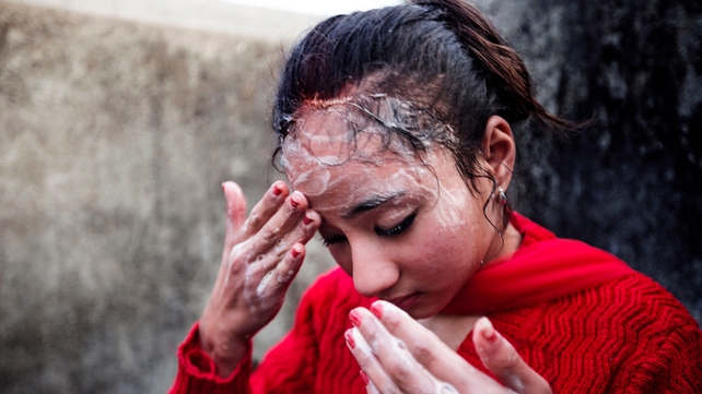 A girl washes her 3rd eye at Bagmati river after completing 12 days of 'Gufa' ritual in Patan, Nepal