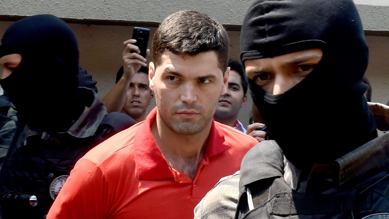 Alleged serial killer Thiago Gomes da Rocha is escorted by police officers the day after his arrest