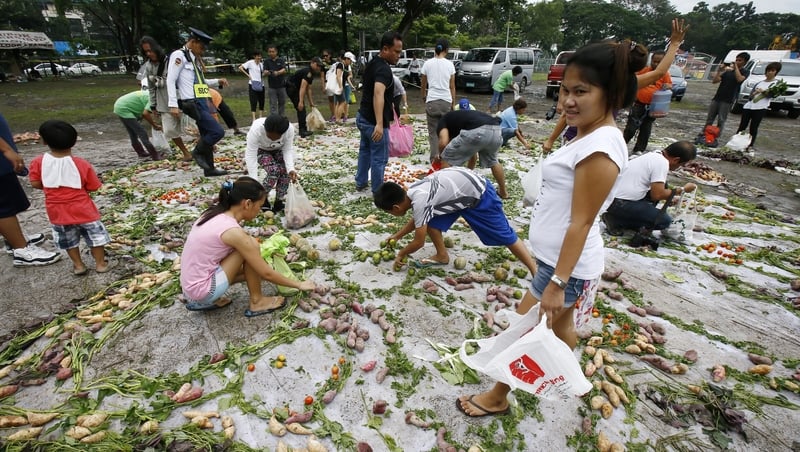 Filipinos collect free vegetables following a food art installation marking post on World Food Day in eastern Manila, Philippines.