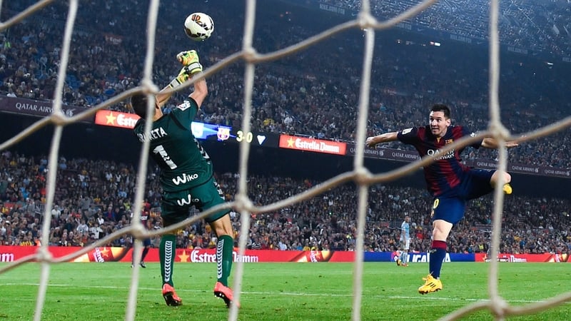 Lionel Mess heads the ball under a challenge by Xabi Irureta of Eibar