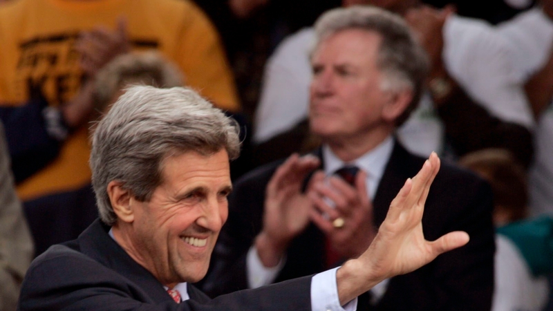 Former US Senator Gary Hart is pictured in the background with US Secretary of State John Kerry in the foreground
