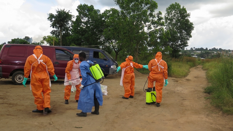 A Red Cross burial team disinfects after recovering a number of bodies outside Freetown in Sierra Leone