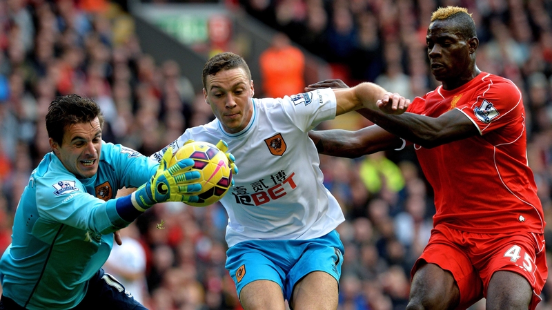 Hull City's goalkeeper Eldin Jakupovic and James Chester defend the ball from Liverpool forward Mario Balotelli