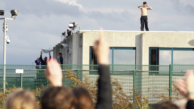 An asylum seeker stands on the roof of repatriation centre in Belgium