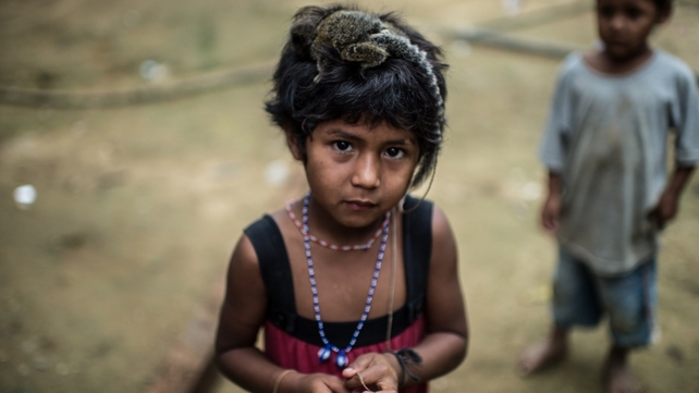 Guarani native girl poses with a monkey on her head at an indigenous reserve near Bracuhy, Brazil