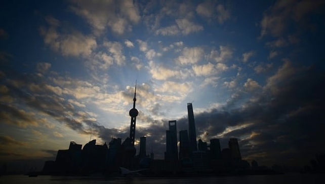 The sun rises behind the skyline of Pudong's Lujiazui Financial District in Shanghai