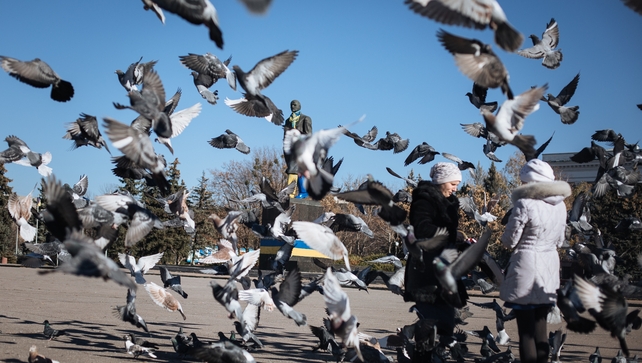 Locals walk near a statue of former Soviet leader Vladimir Lenin at a square in the eastern Ukrainian town Kramatorsk