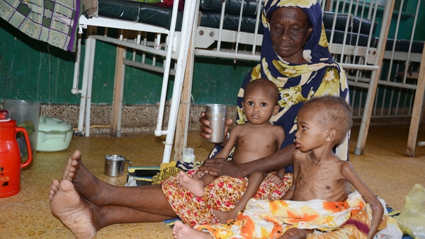 A mother sits with her two malnourished children in a hospital in Mogadishu
