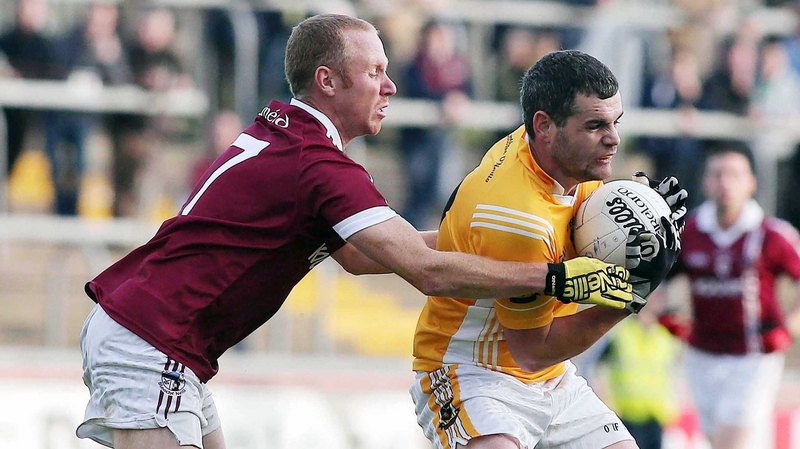 Slaughtneil's Conan Cassidy attempts to dispossess Clontibret's Eoin Greenan