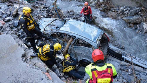 Rescue workers search for a missing person after torrential rain in Serra Ricco' near Genoa