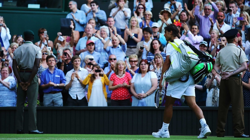 Rafael Nadal walks of after losing his fourth round match against Nick Kyrgios at Wimbledon 2014