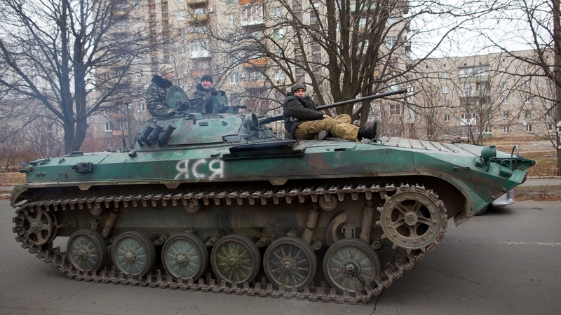 Pro-Russian militants ride on a tank taken from Ukrainian forces in the eastern Ukrainian town of Ilovaisk