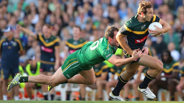 Captain Michael Murphy attempts a tackle on Jobe Watson