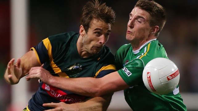 Jobe Watson of Australia gets tackled by Aidan Walsh
