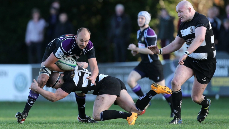 Kieran O'Gorman of Old Belvedere tackles Kyle McCoy