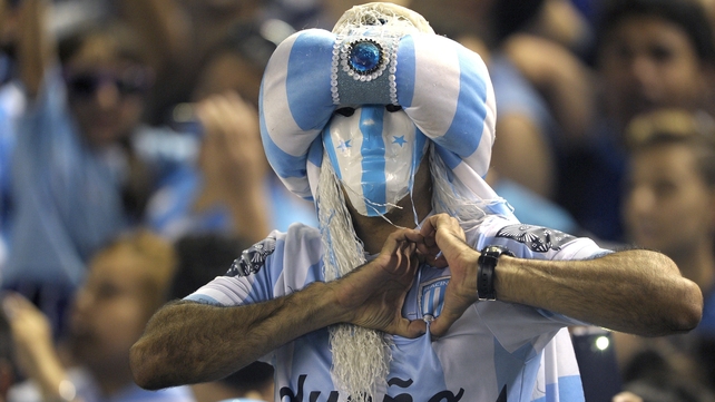 A Racing Club supporter cheers his team during their match against River Plate at Presidente Juan Domingo Peron stadium in Buenos Aires