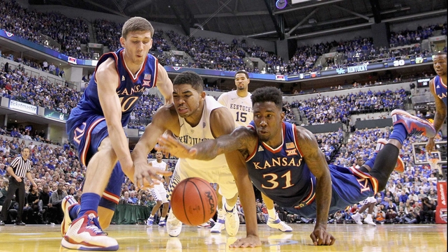 Kansas Jayhwaks players Sviatoslav Mykhailiuk and Jamari Traylor battle for possession with Karl-Anthony Towns of the Kentucky Wildcats at Bankers Life Fieldhouse in Indianapolis