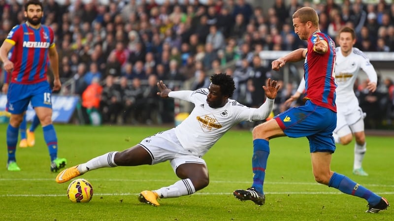 Wilfried Bony of Swansea City shoots past Brede Hangeland of Crystal Palace to score their first goal