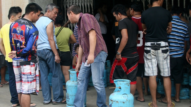 Filipinos queue for liquefied petroleum gas in Tacloban City ahead of the landfall of Typhoon Hagupit
