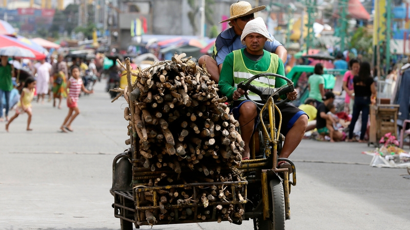 Filipinos transport wooden fuels ahead of pre-emptive evacuation at a slum area in Tondo, Manila