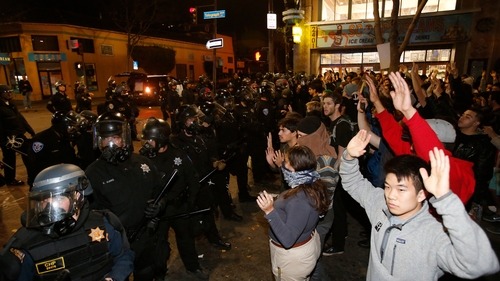 Protesters raise their hands in front of a police line during a demonstration in Berkeley