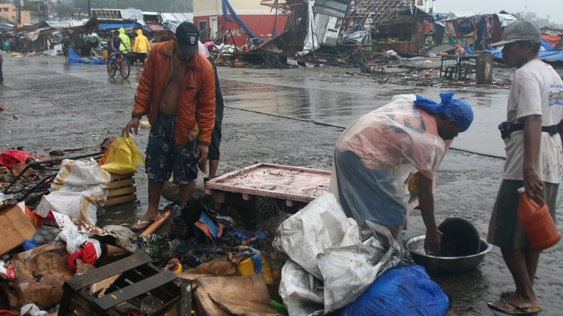 Residents look at debris from destroyed houses in Tacloban, central Philippines