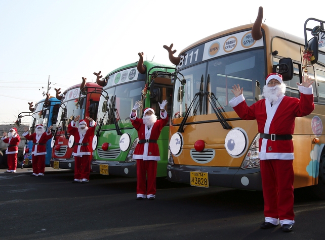 City bus drivers dressed as Santa pose with their buses decorated like Rudolph at a garage in Seoul, South Korea