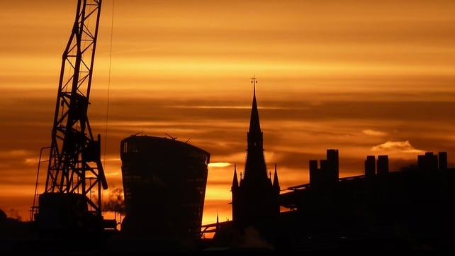 'The Walkie-Talkie' rises behind the gothic tower of the St Pancras Renaissance Hotel at sunrise in London