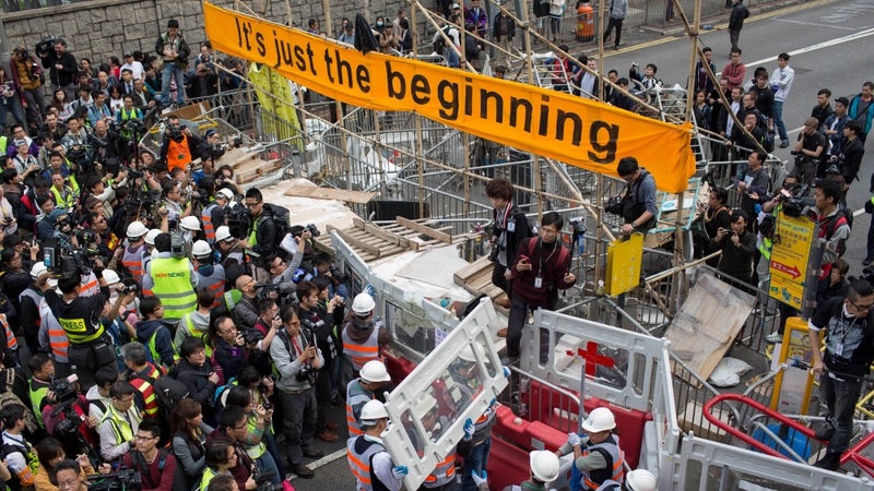 Workers move in to take down barricades at the site