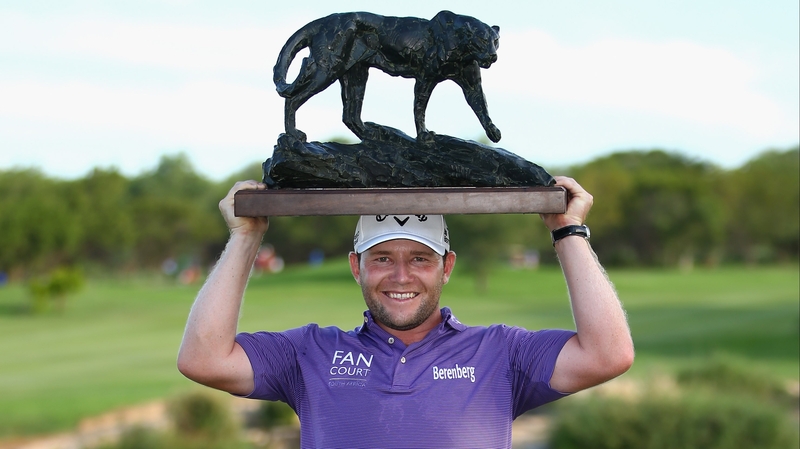 Branden Grace celebrates with a big daft trophy