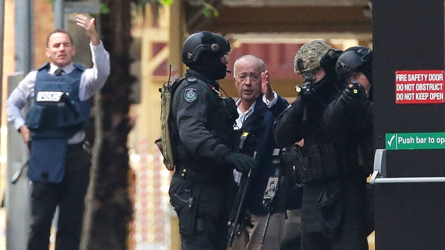 A hostage runs to safety outside the Lindt Café, Martin Place, Sydney