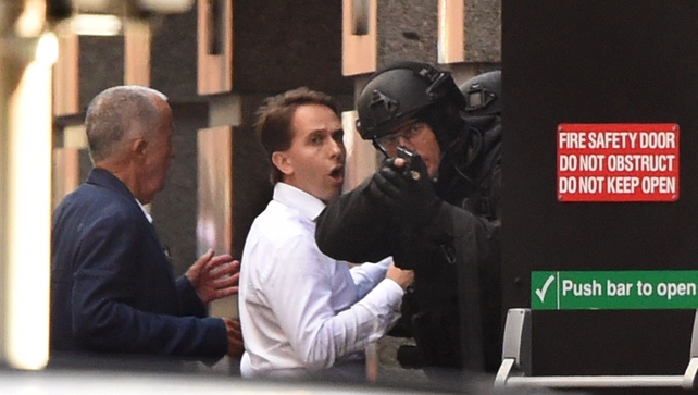 Escaped hostages take cover behind a police officer