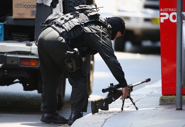 A police sniper sets up on Martin Street