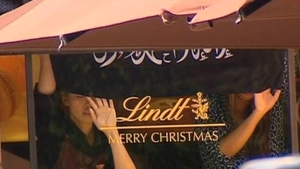 Hostages are forced to hold up a flag in the window of the café