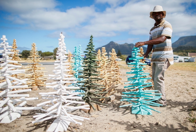 A man sekks Christmas trees on a roadside in Cape Town, South Africa