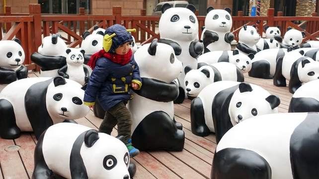 Varied panda sculptures made from wood or bamboo are placed in front of a shopping centre in Luoyang, China