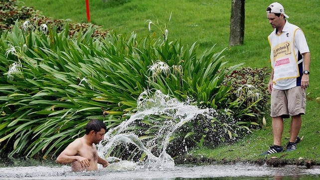 Spain's Pablo Larrazabal jumps into a water hazard to avoid attacking hornets at the Malaysian Open on 18 April