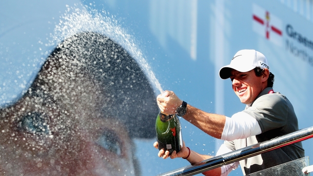 Rory McIlroy celebrates his victory beneath the big screen at Wentworth