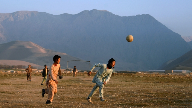 Afghan children play football in a field in a village on the outskirts of Mazar-i-Sharif