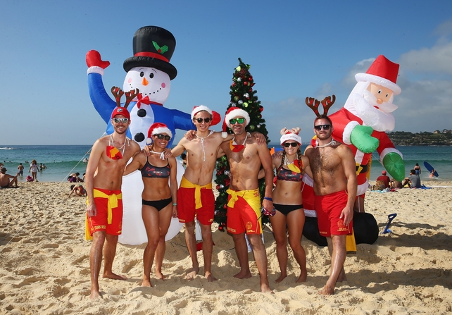 North Bondi surf-club life-savers pose in front of their Christmas decorations at Bondi Beach, in Sydney, Australia