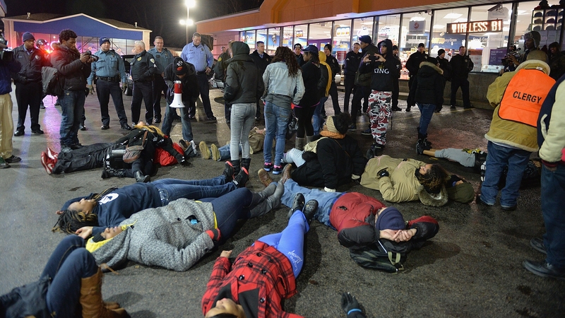 People stage a 'die-in' protest outside the store where the shooting took place
