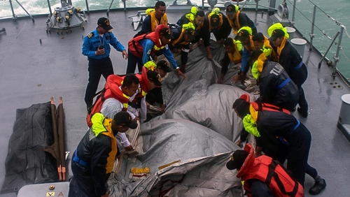 Crew of the Royal Malaysian Navy ship KD Lekir retrieve the emergency evacuation tube from AirAsia flight QZ8501