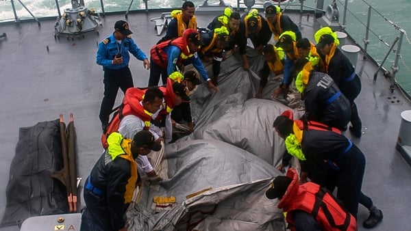 Crew of the Royal Malaysian Navy ship KD Lekir retrieve the emergency evacuation tube from AirAsia flight QZ8501