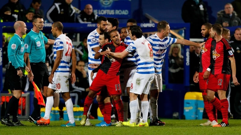 Wayne Routledge is restrained by QPR's Joy Barton after seeing red at Loftus Road