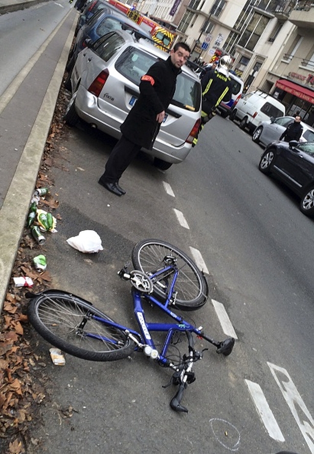 A police officer stands next to the bicycle of a police officer who was hit by a car near the shell of a bullet
