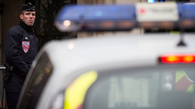 A police officer stands guard next to the 'Charlie Hebdo' headquarters