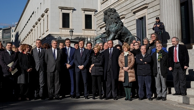 Members of the Spanish Parliament and French Ambassador to Spain Jerome Bonnafont observe a minute's silence outside Parliament