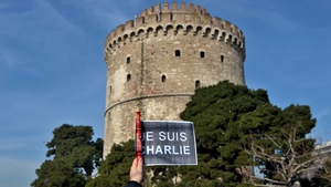 A person holds a sign reading 'je suis Charlie' ('I am Charlie'') in front of the White Tower, the symbol of the city in Thessaloniki, Greece