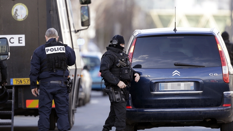 Police officers near the post office where an armed man was holed up with two hostages in Colombes